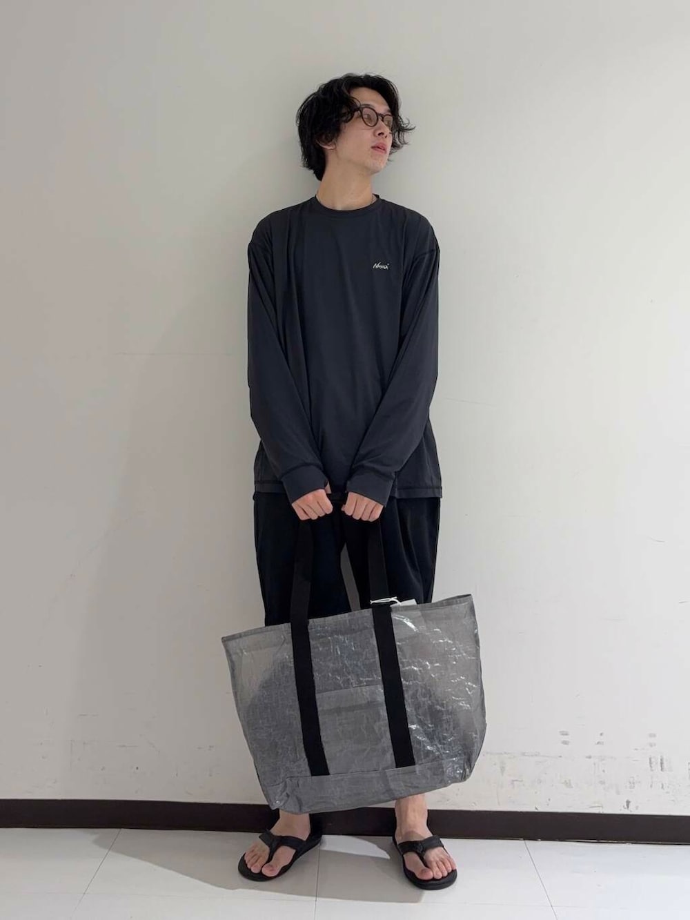 ブルー系のその他パンツ、ブラック系のサンダル、ブラック系のトートバッグを着用したメンズの夏コーディネートの4枚目の写真