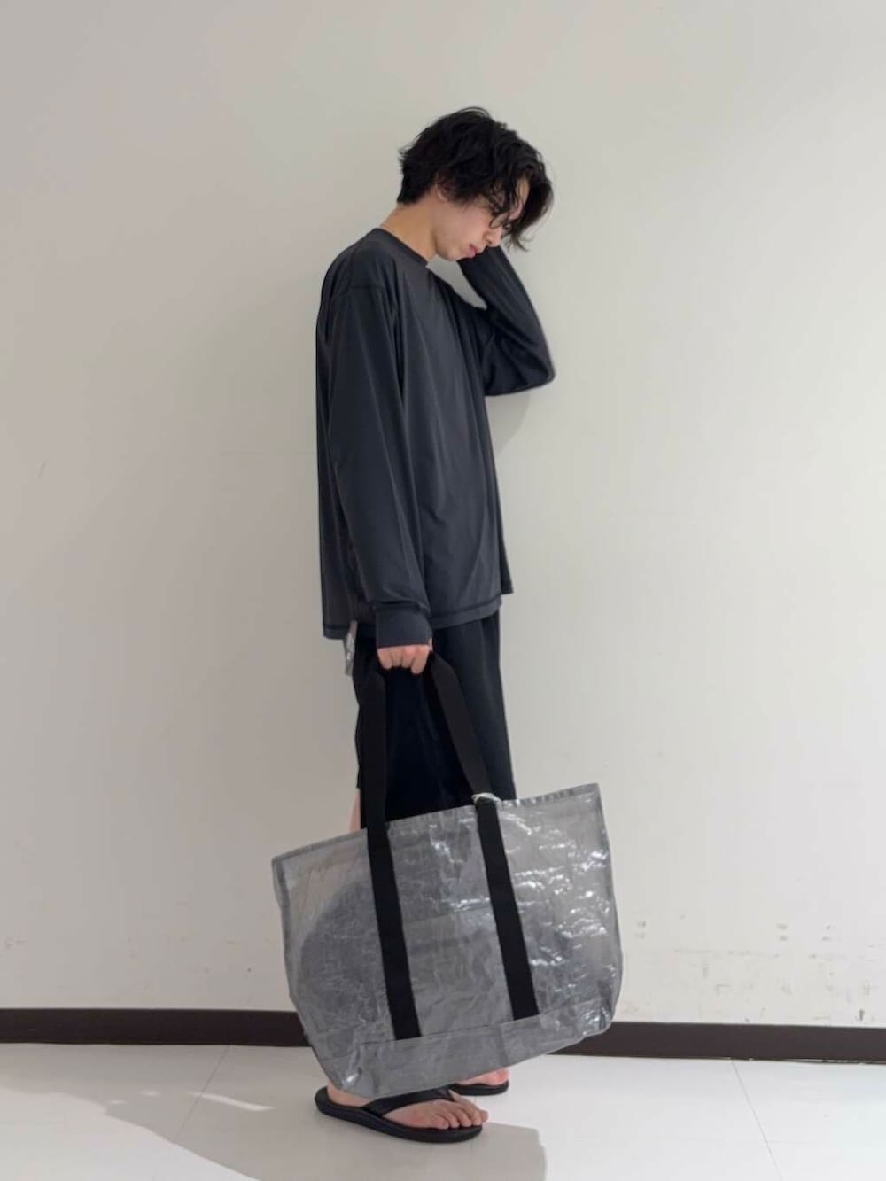 ブルー系のその他パンツ、ブラック系のサンダル、ブラック系のトートバッグを着用したメンズの夏コーディネートの3枚目の写真