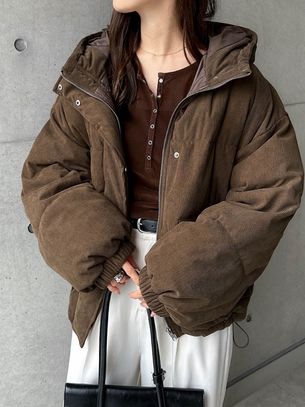 ブラウン系のダウンジャケット/コート、ホワイト系のスラックスを着用したレディースの秋コーディネートの3枚目の写真