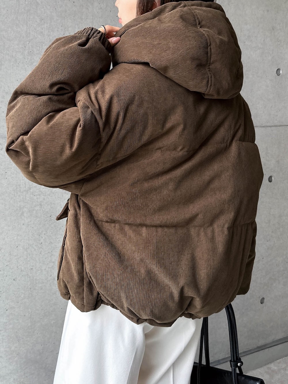 ブラウン系のダウンジャケット/コート、ホワイト系のスラックスを着用したレディースの秋コーディネートの4枚目の写真