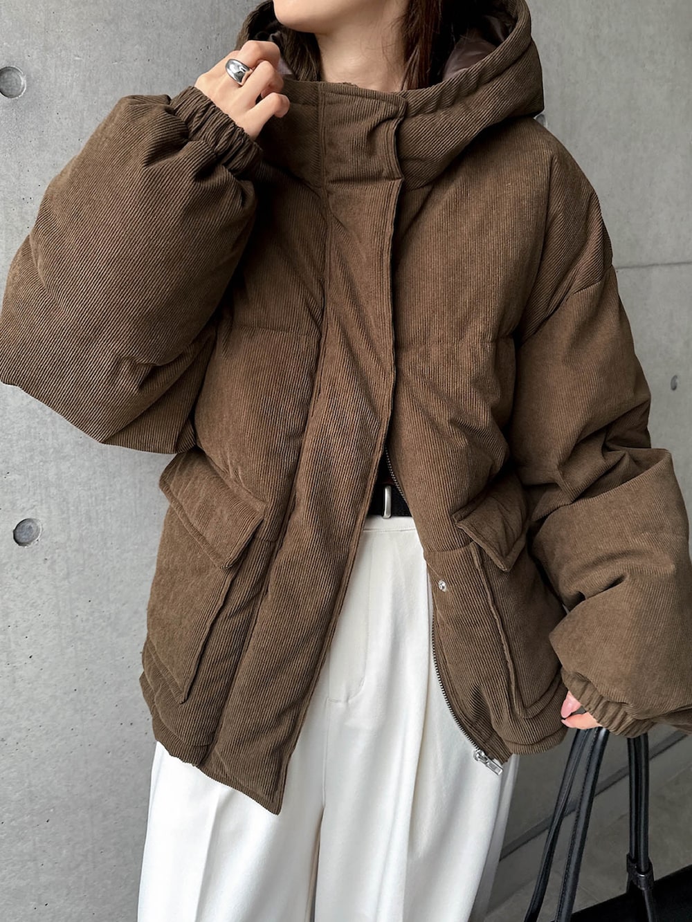 ブラウン系のダウンジャケット/コート、ホワイト系のスラックスを着用したレディースの秋コーディネートの2枚目の写真