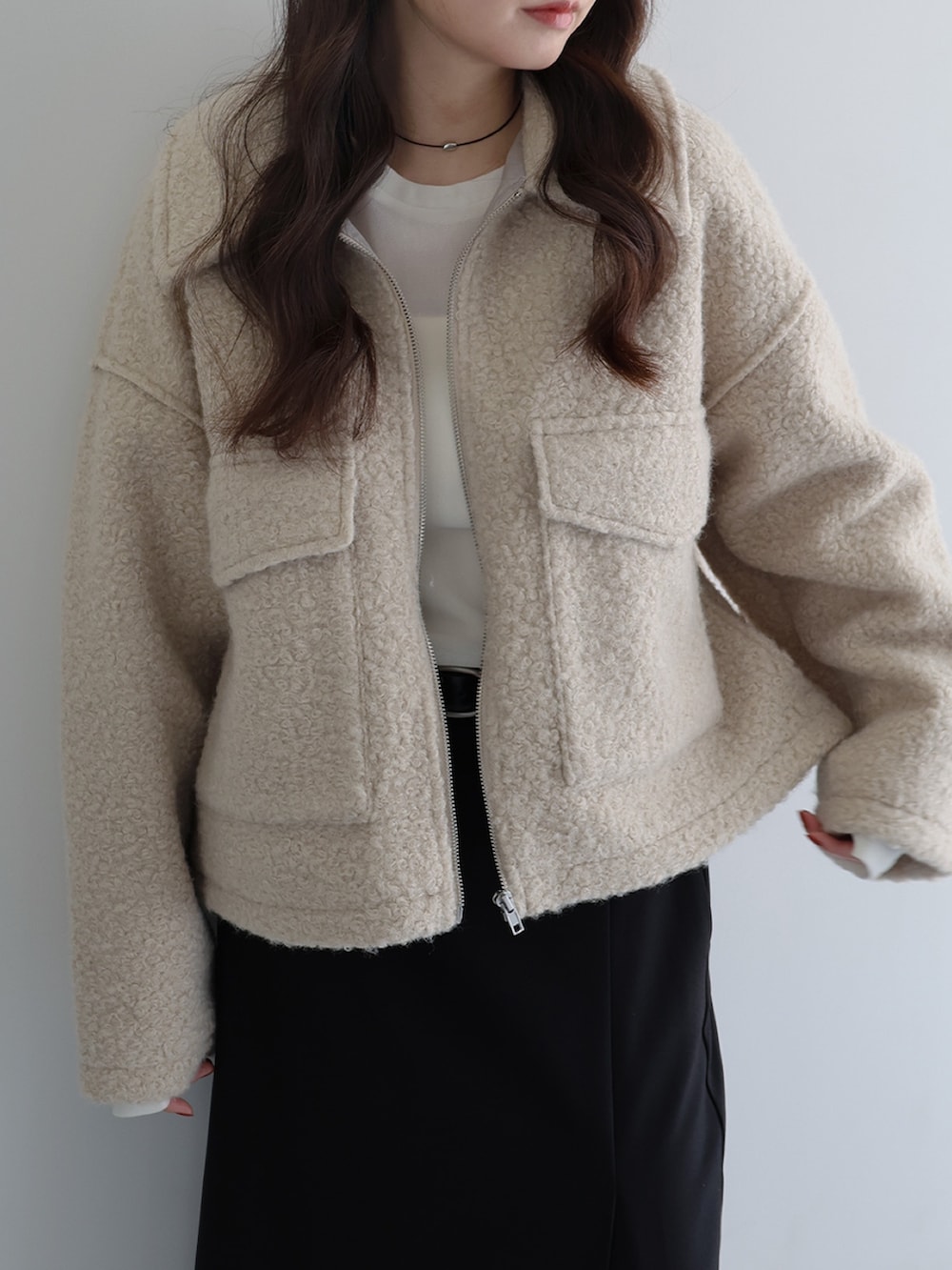 ベージュ系のブルゾン、ホワイト系のTシャツ/カットソー、ブラック系のスカートを着用したレディースの冬コーディネートの2枚目の写真