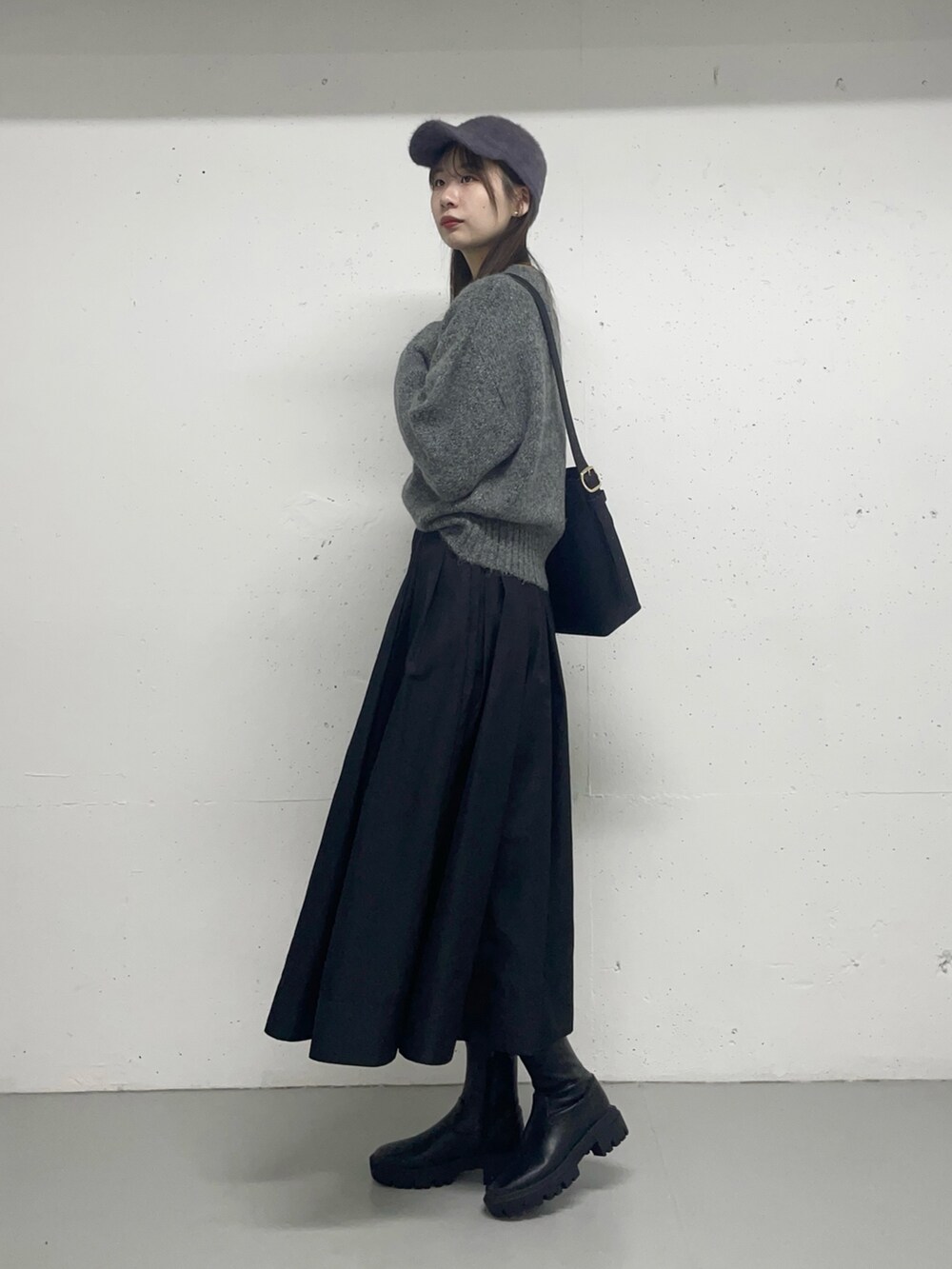 ブラック系のスカートを着用したレディースの秋コーディネートの2枚目の写真