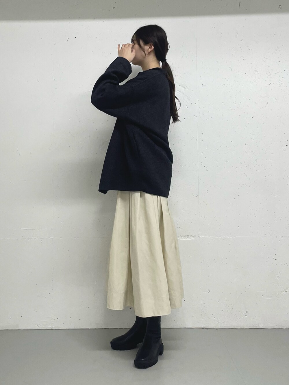 グレー系のその他アウター、ブラック系のスカートを着用したレディースの秋コーディネートの2枚目の写真