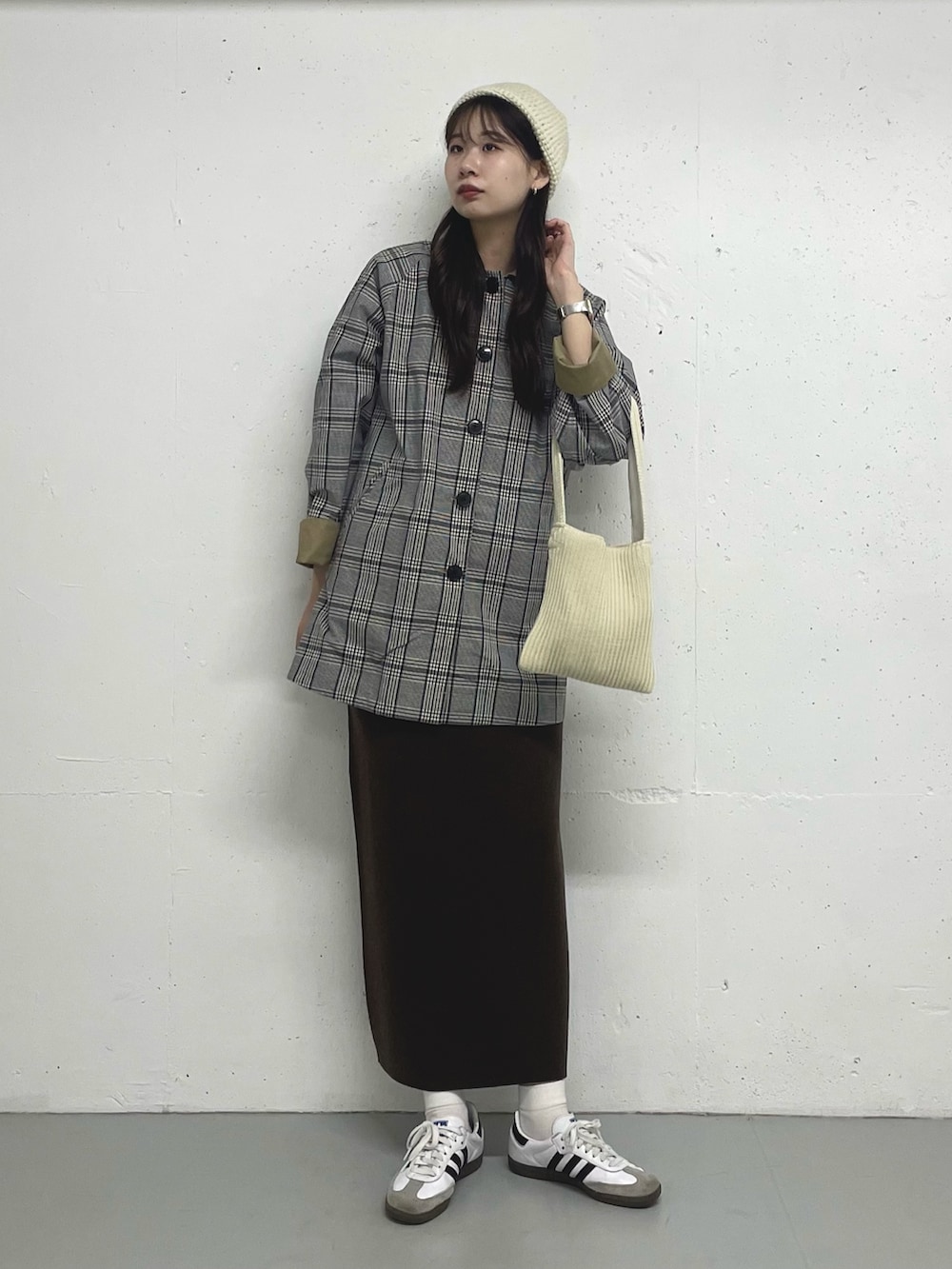 ベージュ系のステンカラーコートを着用したレディースの秋コーディネートの3枚目の写真