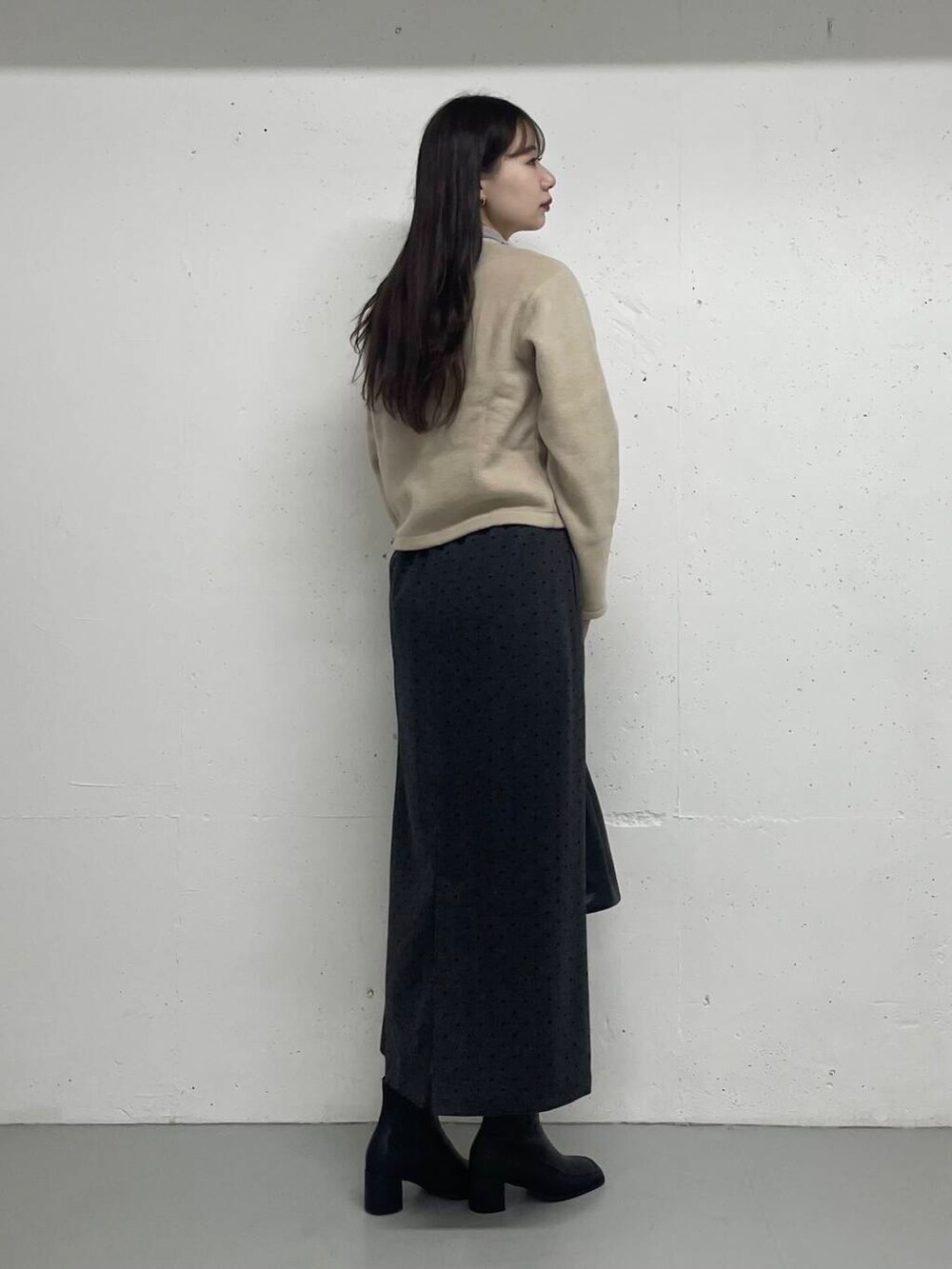 グレー系のTシャツ/カットソー、ベージュ系のカーディガン/ボレロ、グレー系のスカートを着用したレディースの秋コーディネートの3枚目の写真