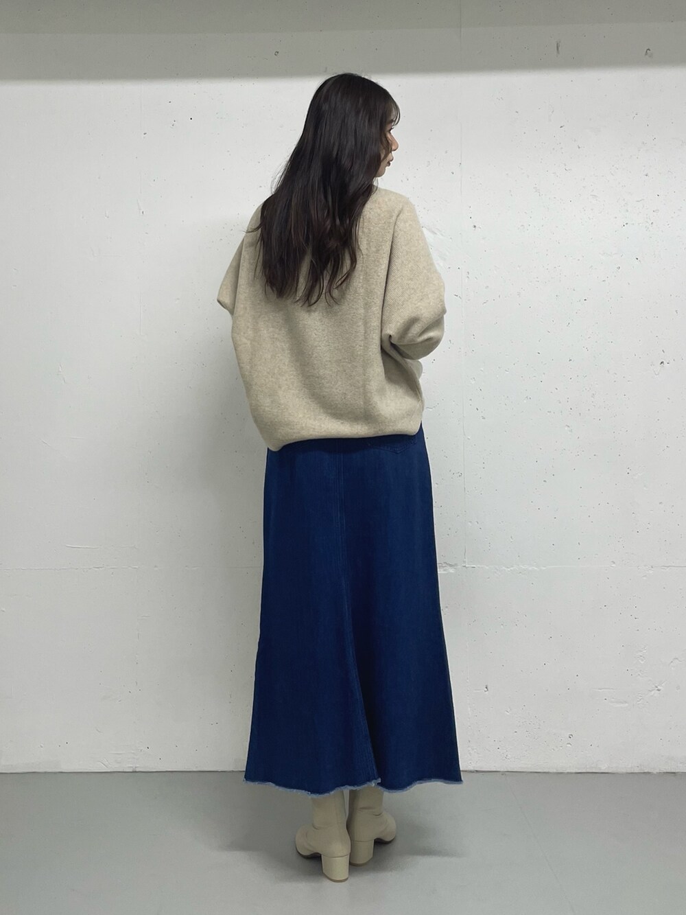 ブルー系のスカート、ベージュ系のニット/セーターを着用したレディースの秋コーディネートの3枚目の写真