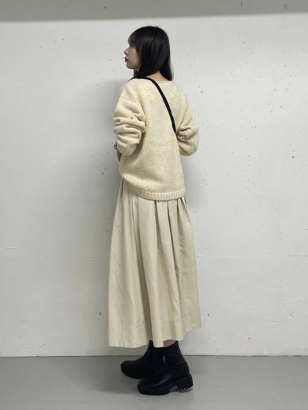 ホワイト系のニット/セーター、ホワイト系のスカートを着用したレディースの秋コーディネートの2枚目の写真