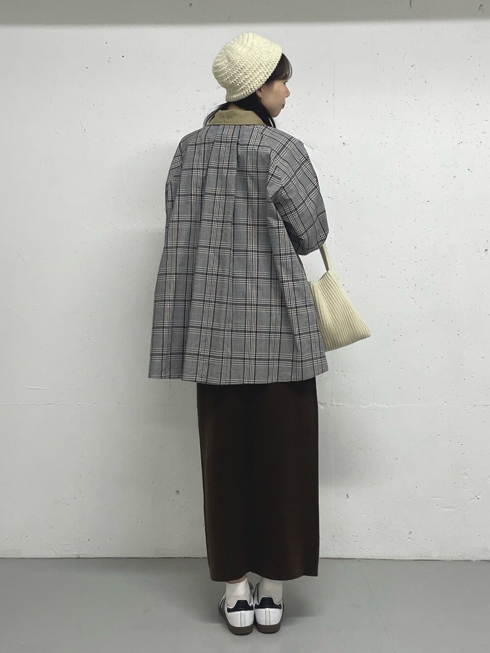 ベージュ系のステンカラーコートを着用したレディースの秋コーディネートの4枚目の写真