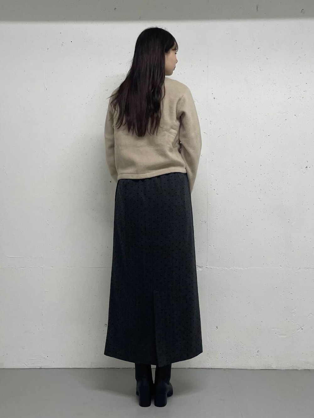 グレー系のTシャツ/カットソー、ベージュ系のカーディガン/ボレロ、グレー系のスカートを着用したレディースの秋コーディネートの4枚目の写真