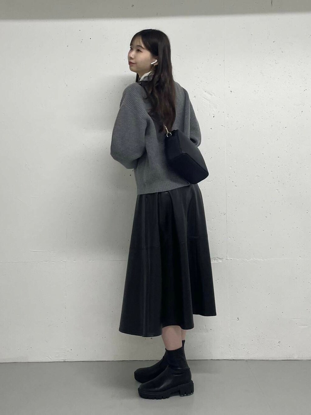 グレー系のカーディガン/ボレロ、ホワイト系のTシャツ/カットソー、ブラック系のスカートを着用したレディースの秋コーディネートの2枚目の写真