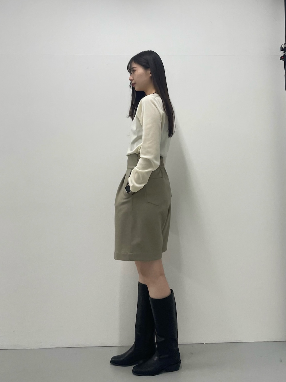 グリーン系のTシャツ/カットソー、ベージュ系のその他パンツ、ブラック系のブーツを着用したレディースの秋コーディネートの2枚目の写真