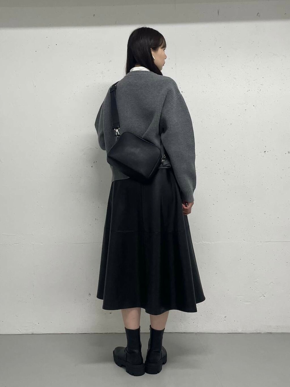 グレー系のカーディガン/ボレロ、ホワイト系のTシャツ/カットソー、ブラック系のスカートを着用したレディースの秋コーディネートの4枚目の写真