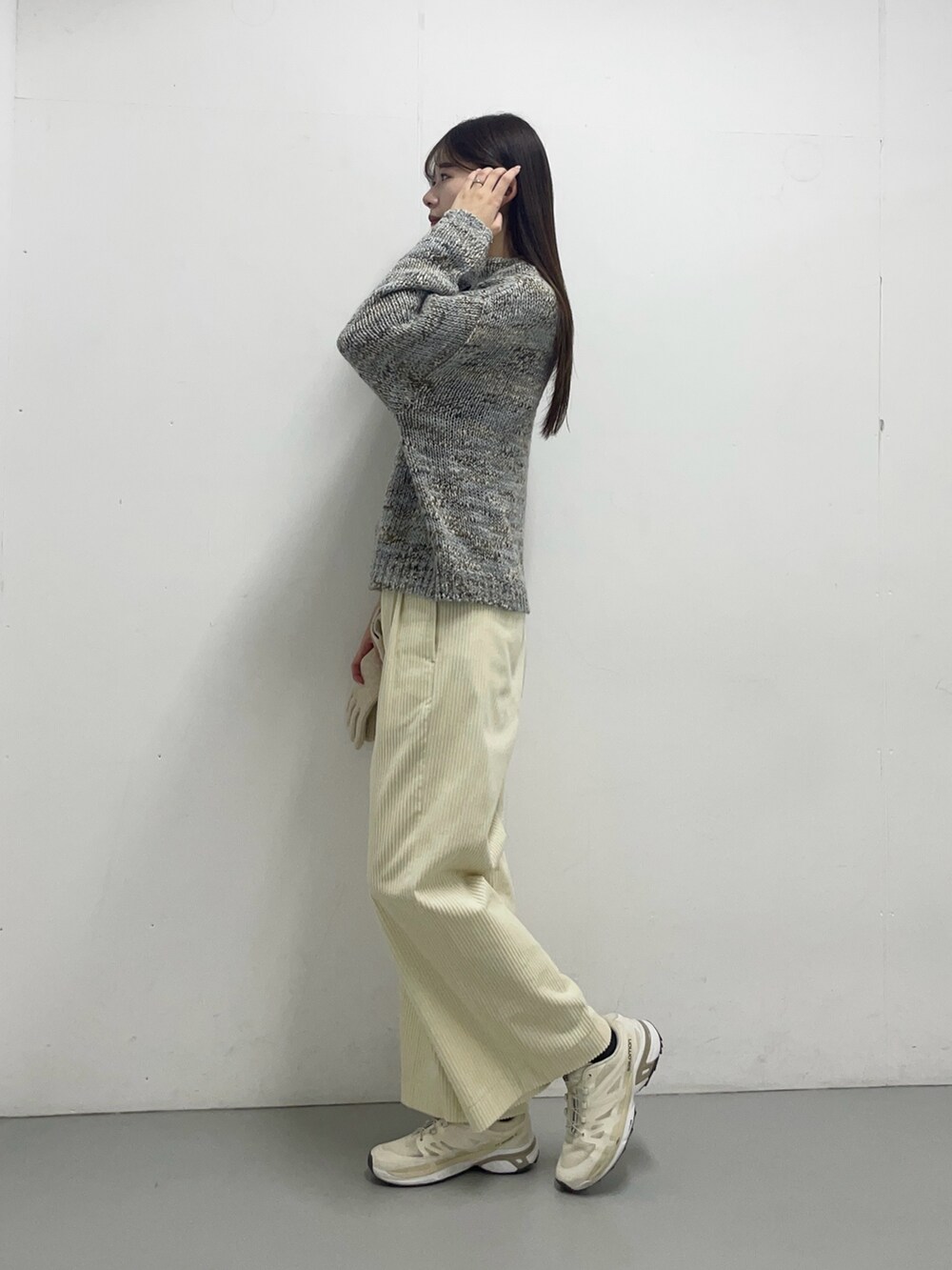 グレー系のニット/セーター、ホワイト系のその他パンツを着用したレディースの秋コーディネートの3枚目の写真