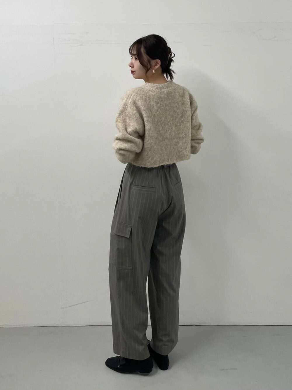 グレー系のその他パンツ、ベージュ系のニット/セーターを着用したレディースの秋コーディネートの2枚目の写真