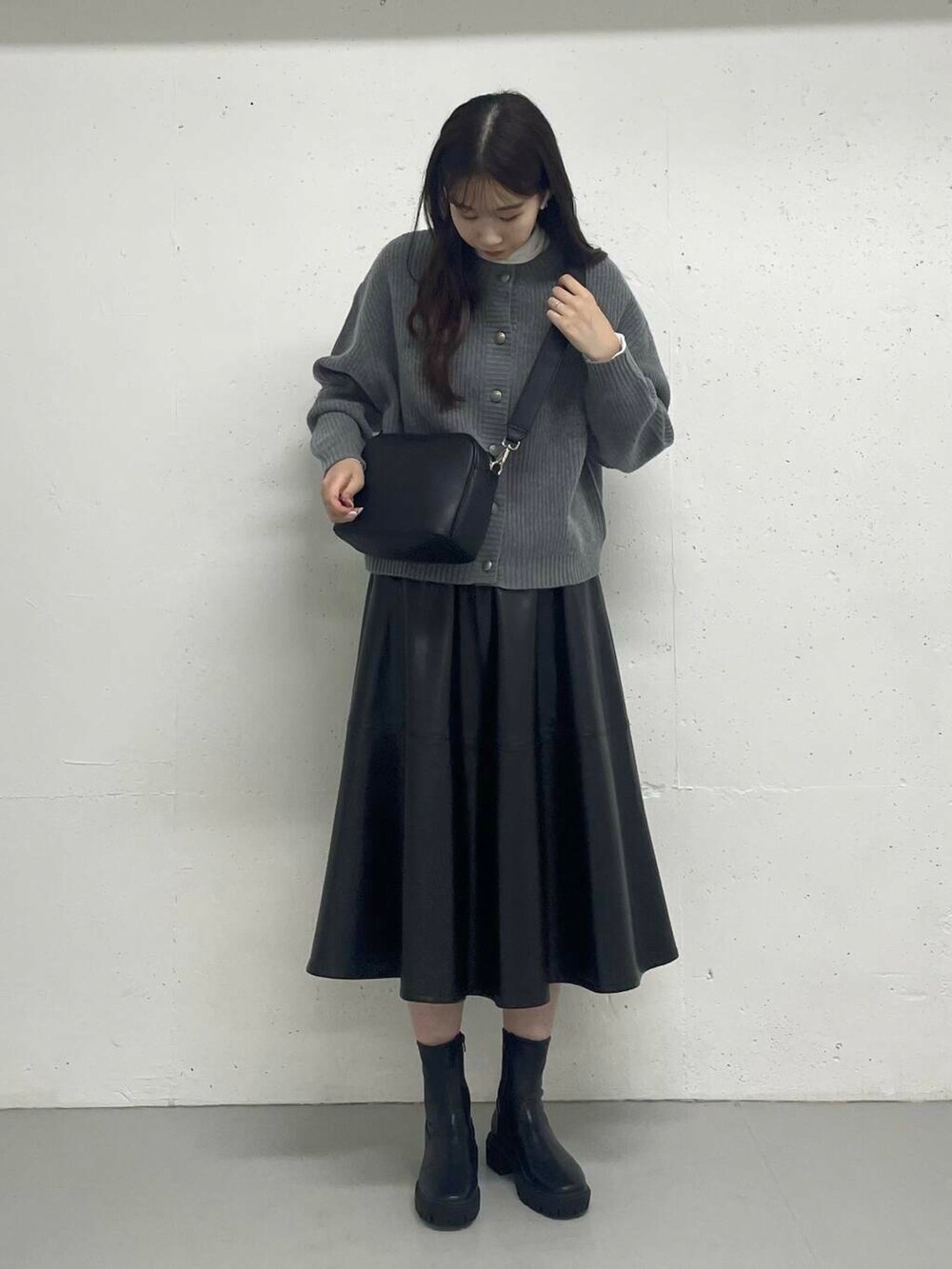 グレー系のカーディガン/ボレロ、ホワイト系のTシャツ/カットソー、ブラック系のスカートを着用したレディースの秋コーディネートの3枚目の写真