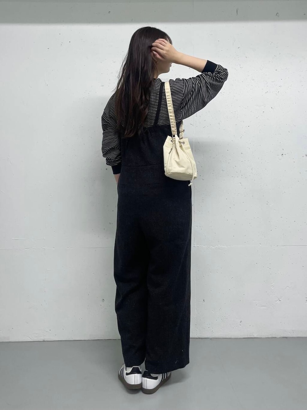 ブラック系のTシャツ/カットソー、グレー系のサロペット/オーバーオールを着用したレディースの秋コーディネートの4枚目の写真