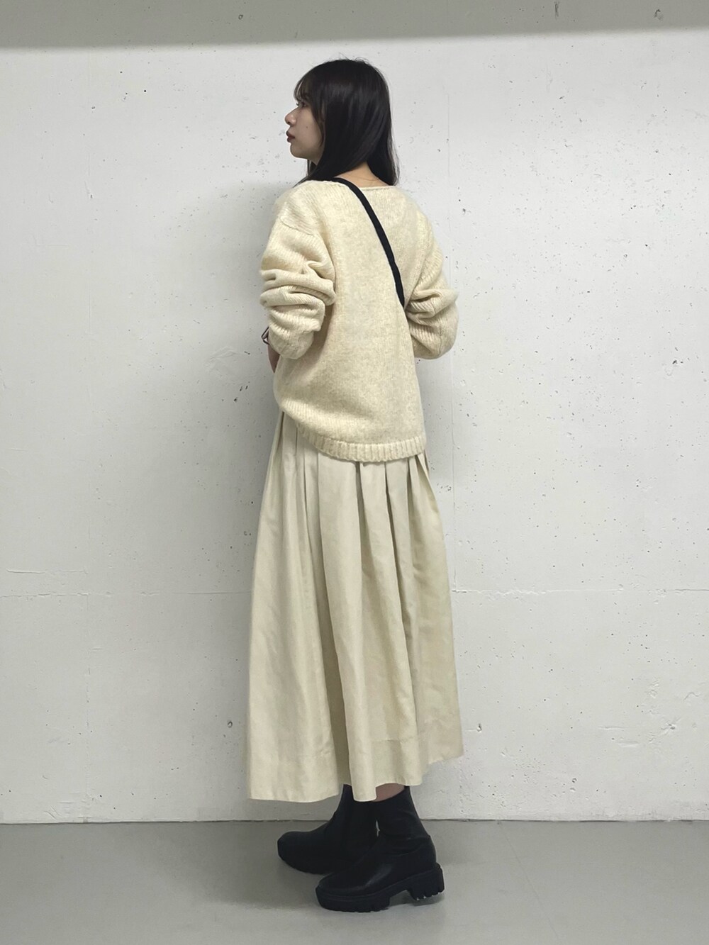 ブラック系のスカートを着用したレディースの秋コーディネートの2枚目の写真