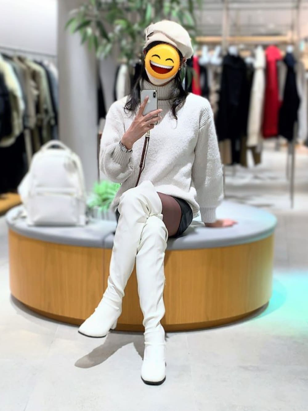 ホワイト系のブーツ、ブラック系のその他パンツ、ホワイト系のニット/セーターを着用したレディースの冬コーディネートの2枚目の写真