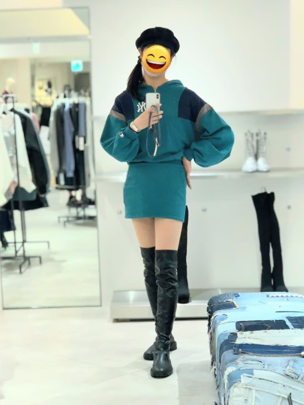 グリーン系のワンピース、ブラック系のブーツ、ブラック系のキャスケットを着用したレディースの秋コーディネートの2枚目の写真