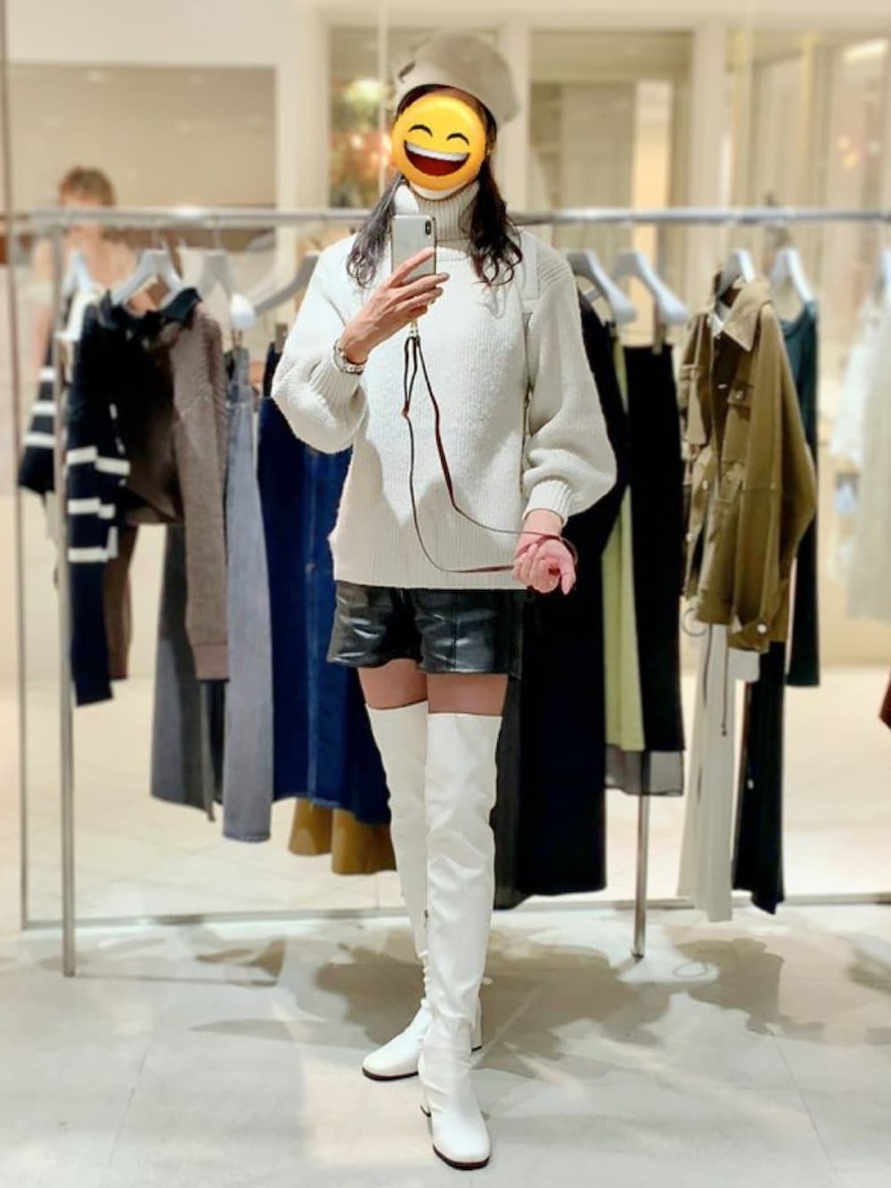 ホワイト系のブーツ、ブラック系のその他パンツ、ホワイト系のニット/セーターを着用したレディースの冬コーディネートの3枚目の写真