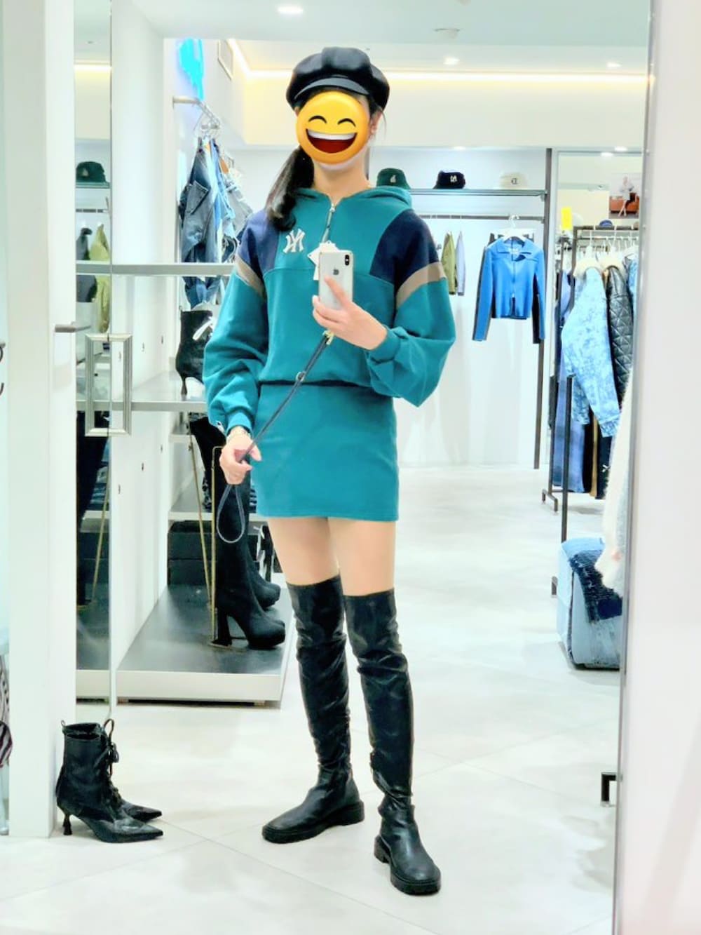 グリーン系のワンピース、ブラック系のブーツ、ブラック系のキャスケットを着用したレディースの秋コーディネートの3枚目の写真