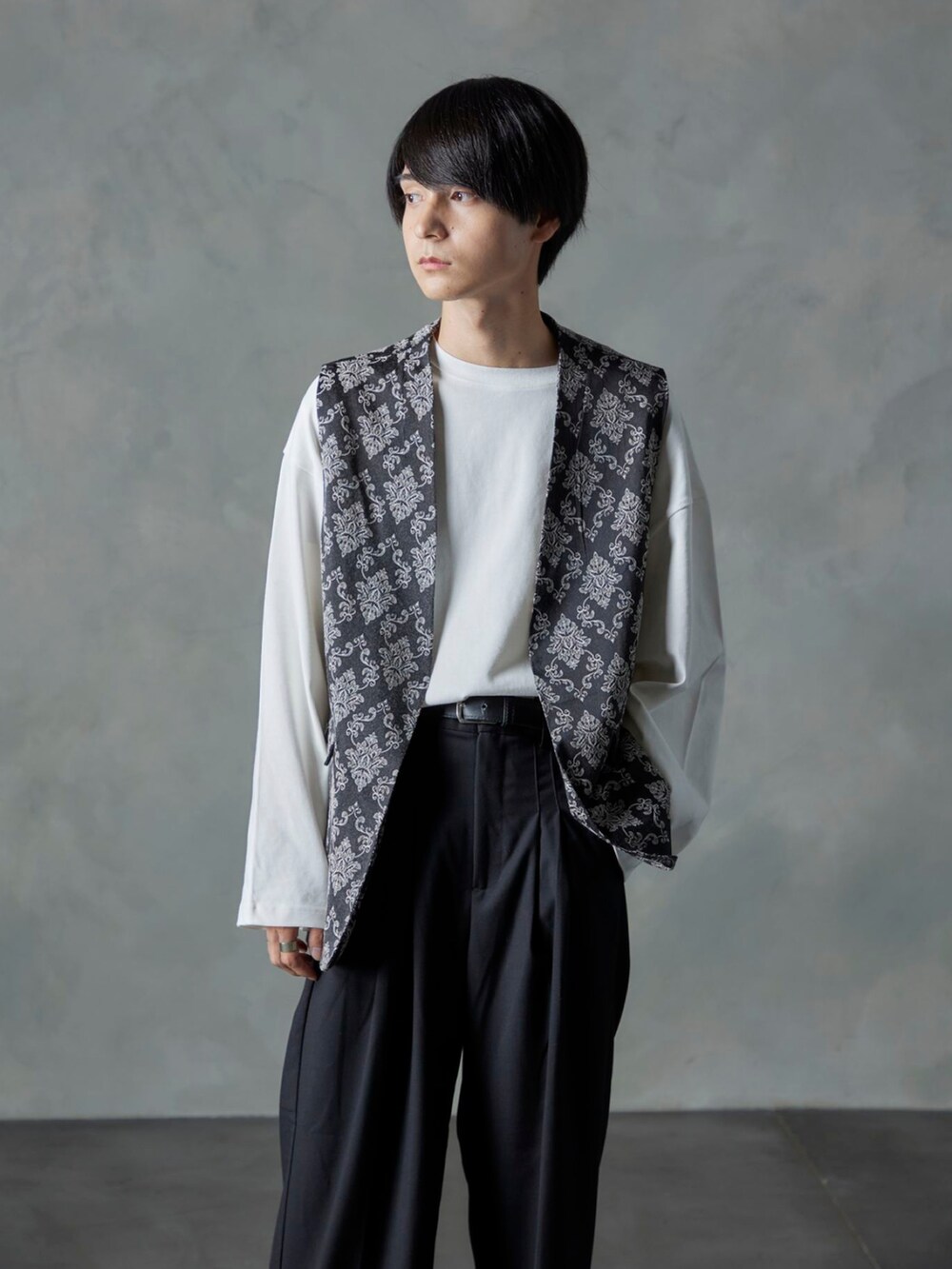 ブラック系のスラックス、ブラック系のベスト、ホワイト系のTシャツ/カットソーを着用したメンズの秋コーディネートの5枚目の写真