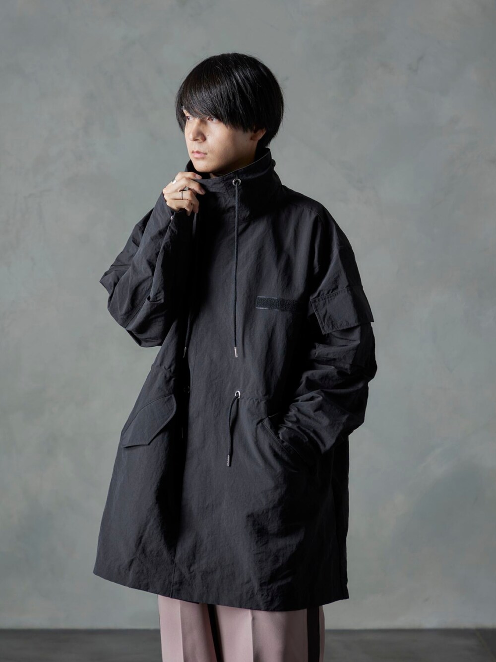 ピンク系のスラックス、ブラック系のモッズコートを着用したメンズの秋コーディネートの3枚目の写真