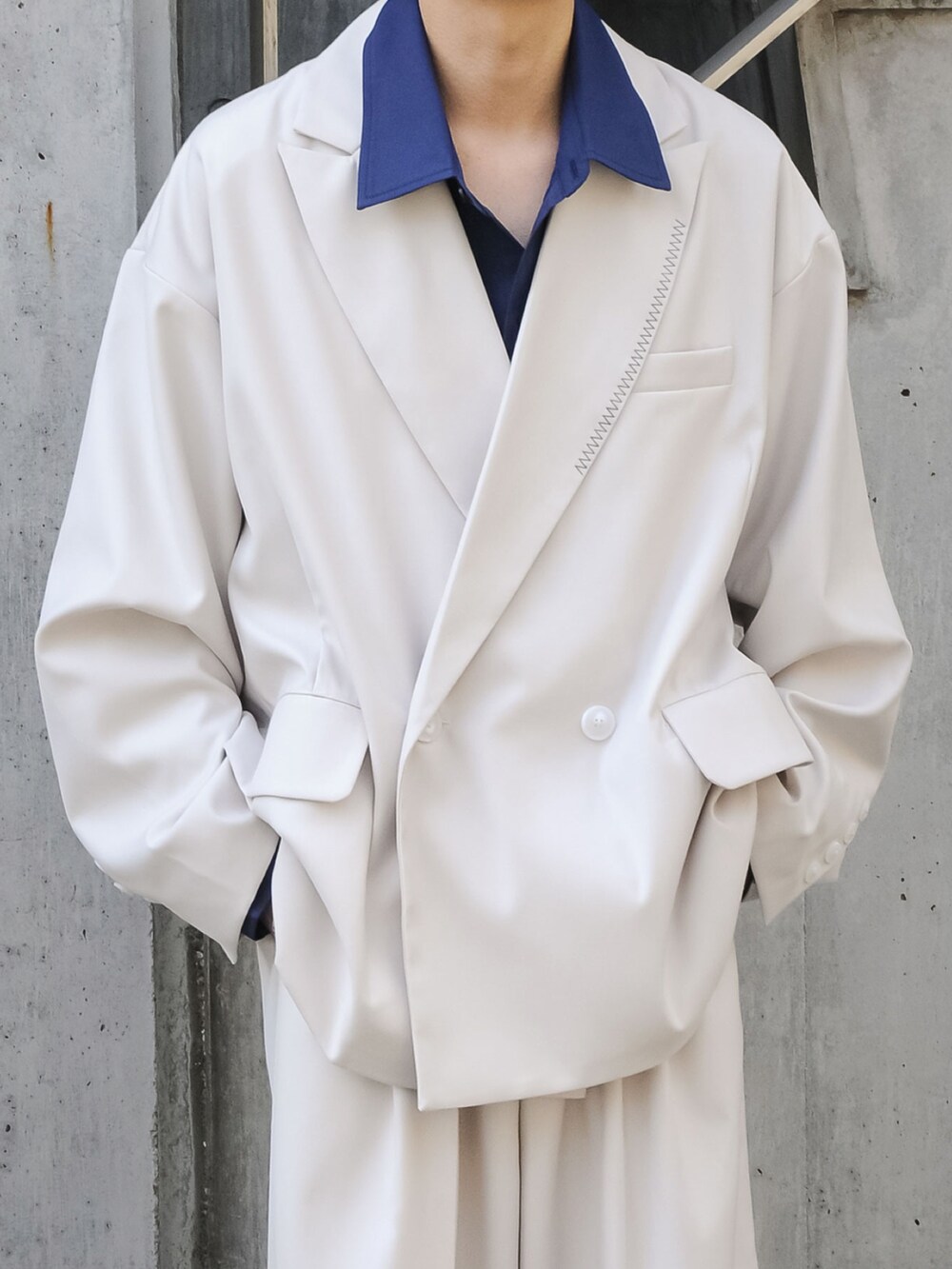 グレー系のテーラードジャケット、グレー系のスラックスを着用したメンズの冬コーディネートの2枚目の写真