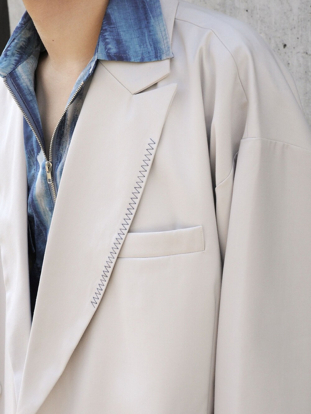 グレー系のテーラードジャケット、グレー系のスラックスを着用したメンズの冬コーディネートの3枚目の写真