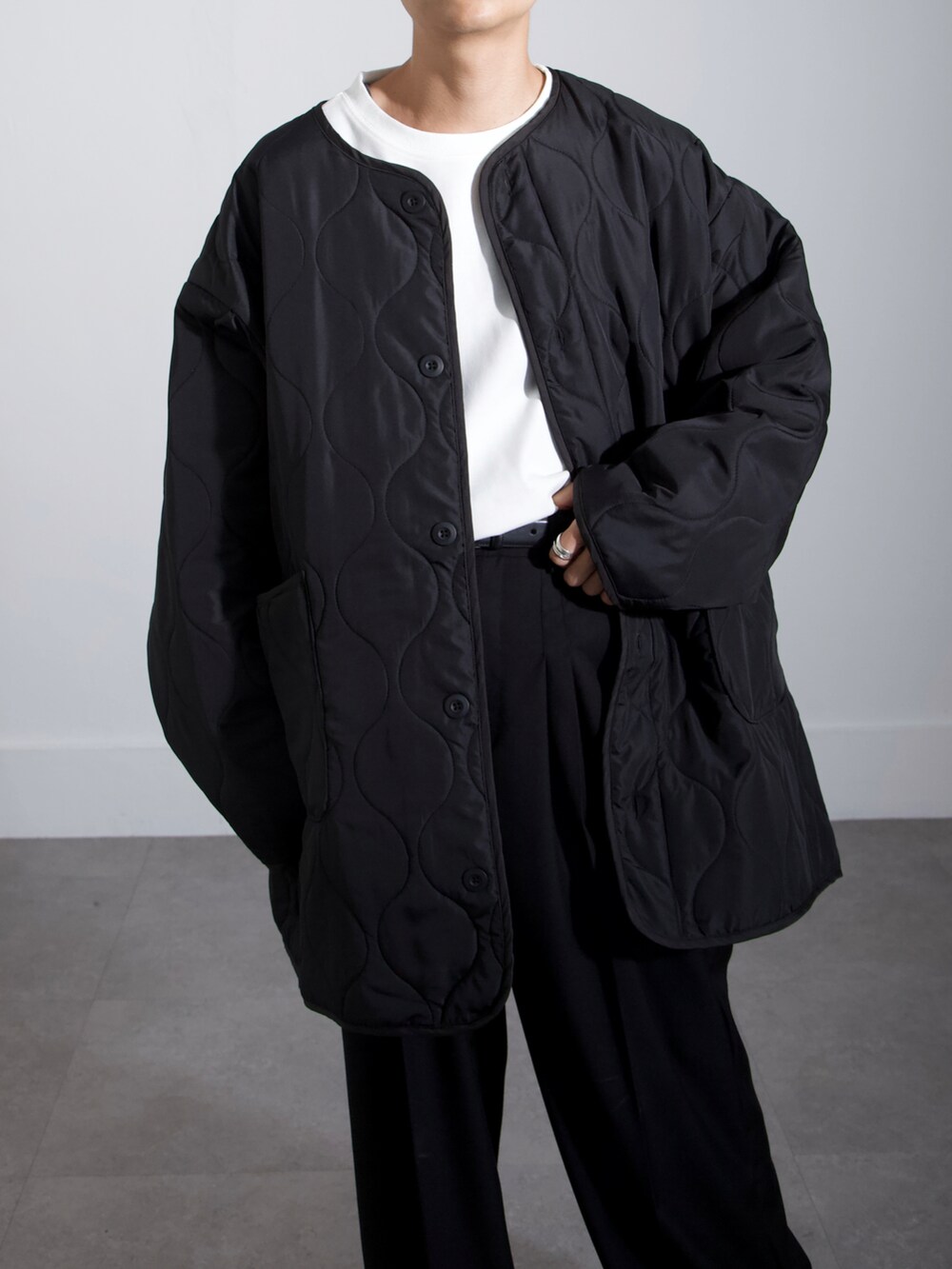 ホワイト系のTシャツ/カットソー、ブラック系のノーカラーコート、ブラック系のスラックスを着用したメンズの秋コーディネートの3枚目の写真