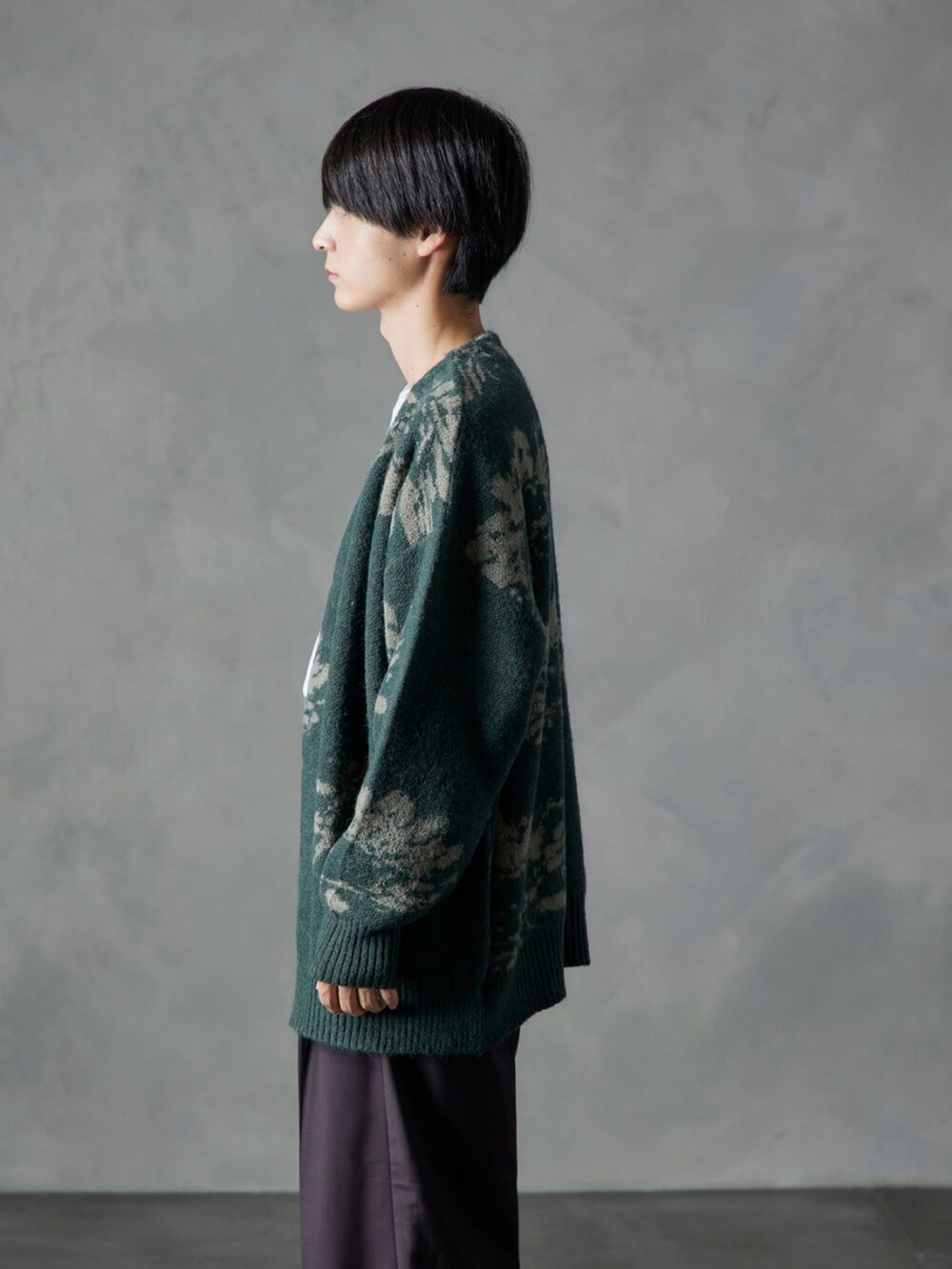 ホワイト系のTシャツ/カットソー、ブラウン系のスラックス、グリーン系のカーディガン/ボレロを着用したメンズの秋コーディネートの2枚目の写真