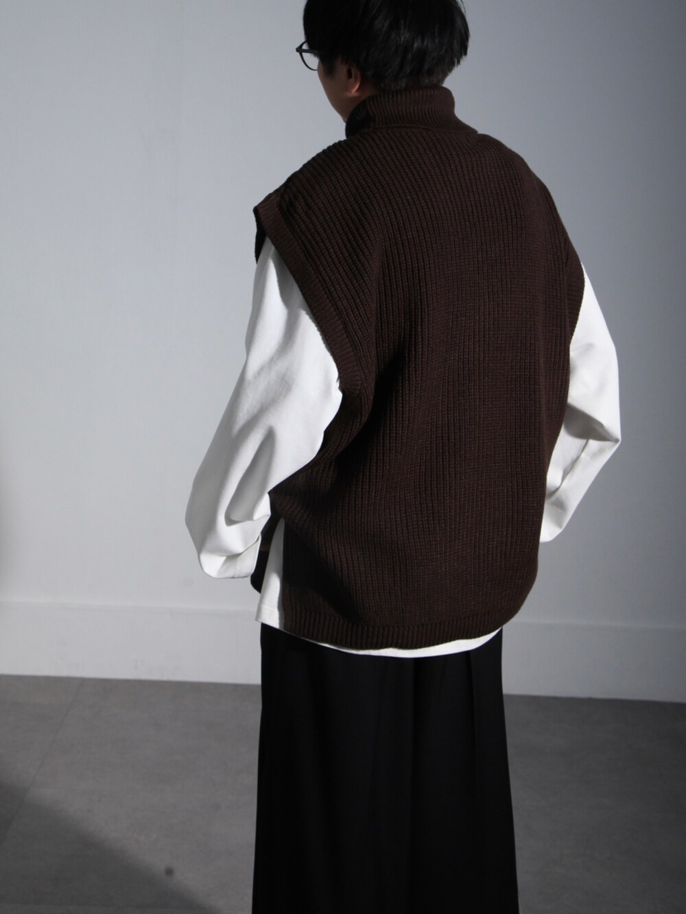 ホワイト系のTシャツ/カットソー、ブラウン系のベスト、ブラック系のスラックスを着用したメンズの秋コーディネートの3枚目の写真