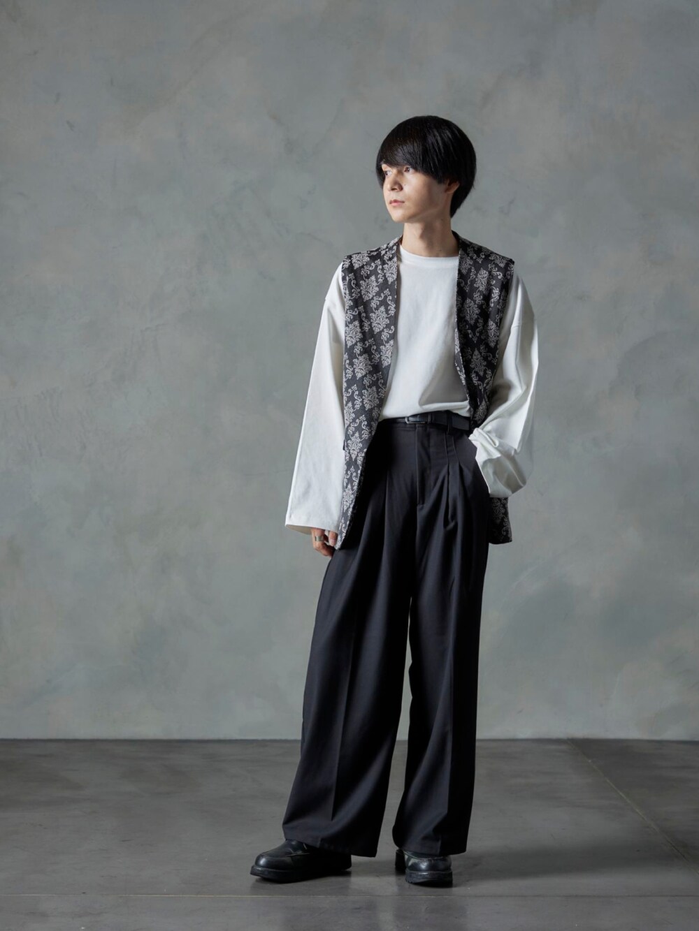 ブラック系のスラックス、ブラック系のベスト、ホワイト系のTシャツ/カットソーを着用したメンズの秋コーディネートの2枚目の写真