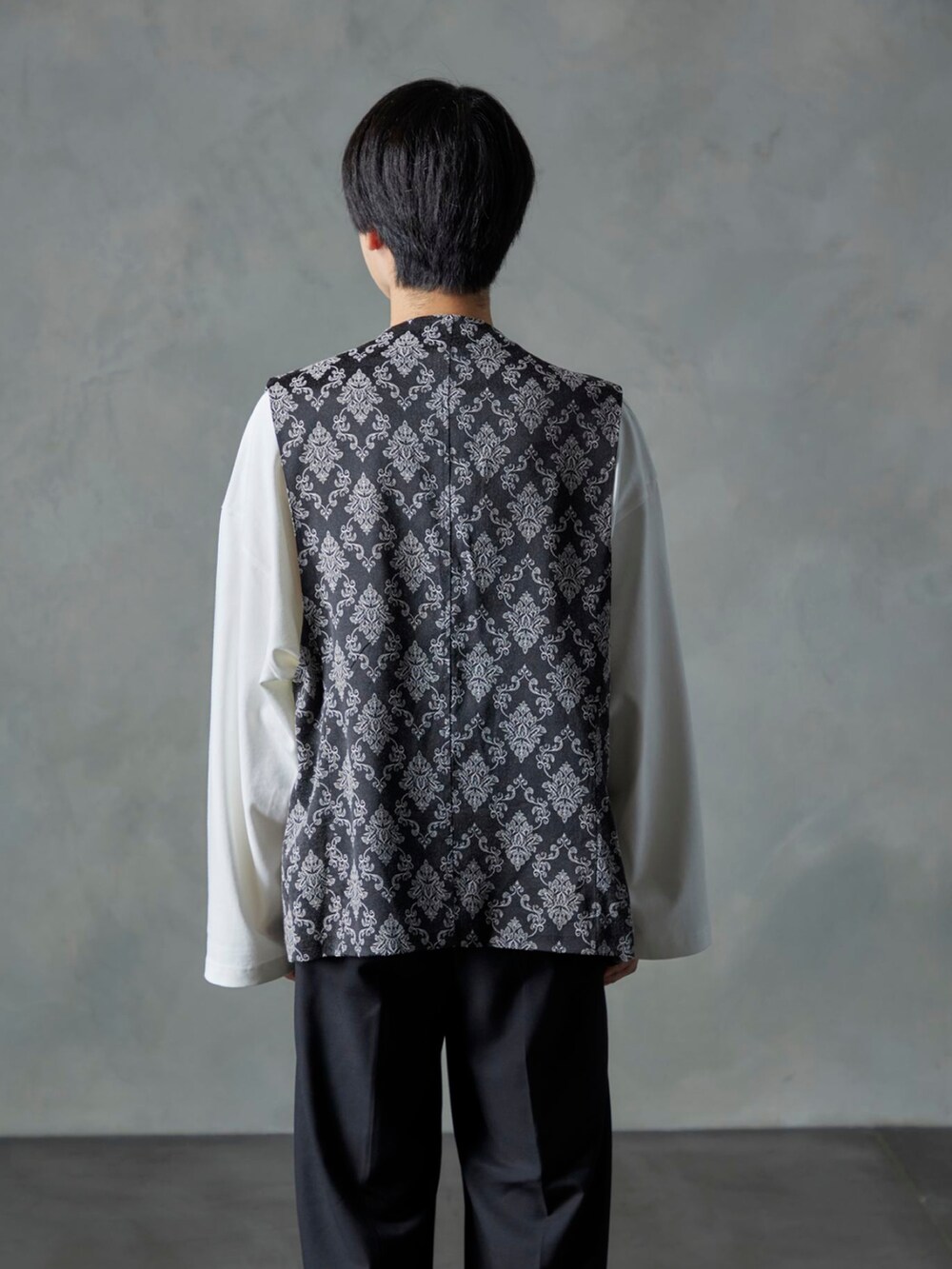 ブラック系のスラックス、ブラック系のベスト、ホワイト系のTシャツ/カットソーを着用したメンズの秋コーディネートの4枚目の写真