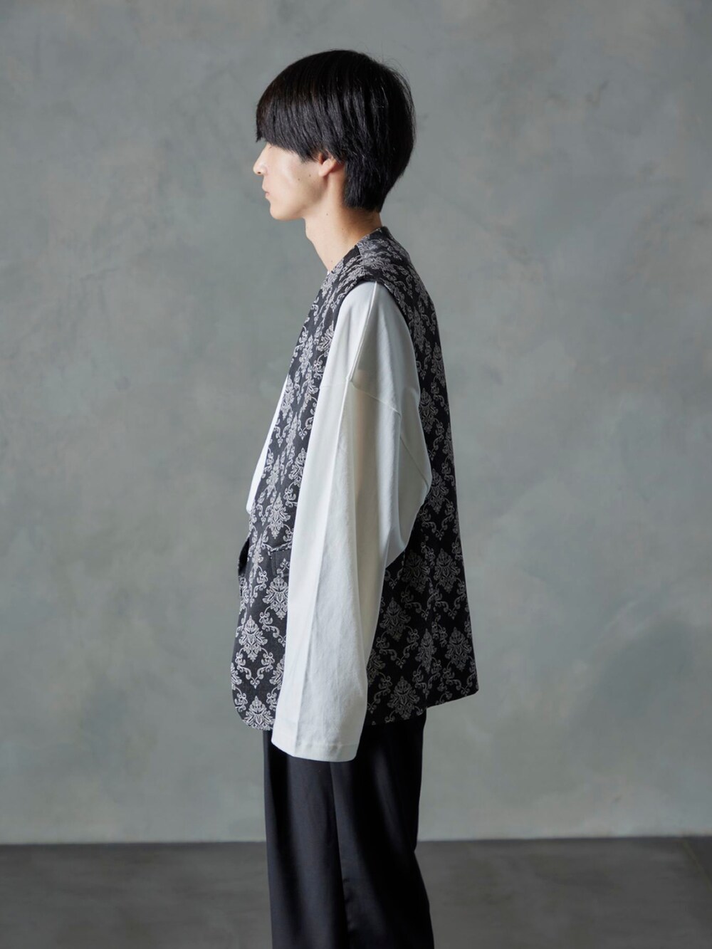 ブラック系のスラックス、ブラック系のベスト、ホワイト系のTシャツ/カットソーを着用したメンズの秋コーディネートの3枚目の写真