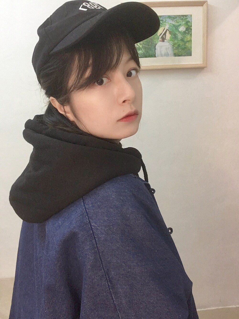 ブルー系のジャケット/アウター、ブラック系のパーカー、ブラック系のキャップを着用したレディースの冬コーディネートの2枚目の写真