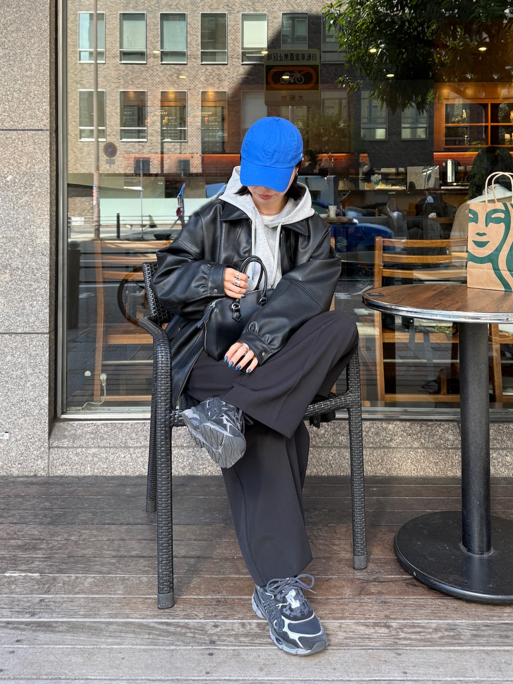 グレー系のパーカー、ブラック系のその他パンツ、ブラック系のブルゾンを着用したレディースの秋コーディネートの4枚目の写真