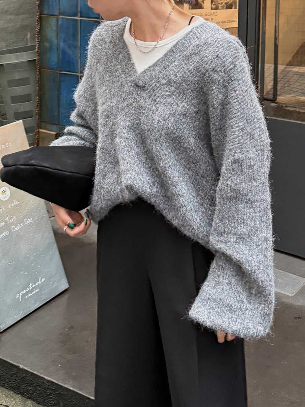 グレー系のニット/セーター、ホワイト系のTシャツ/カットソー、ブラック系のその他パンツを着用したレディースの秋コーディネートの5枚目の写真