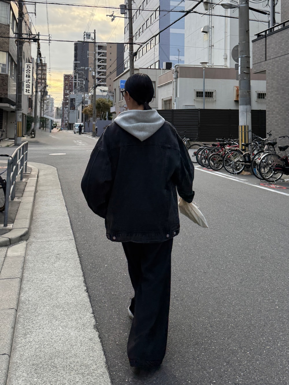 グレー系のパーカー、ホワイト系のTシャツ/カットソー、ブラック系のブルゾンを着用したレディースの秋コーディネートの5枚目の写真