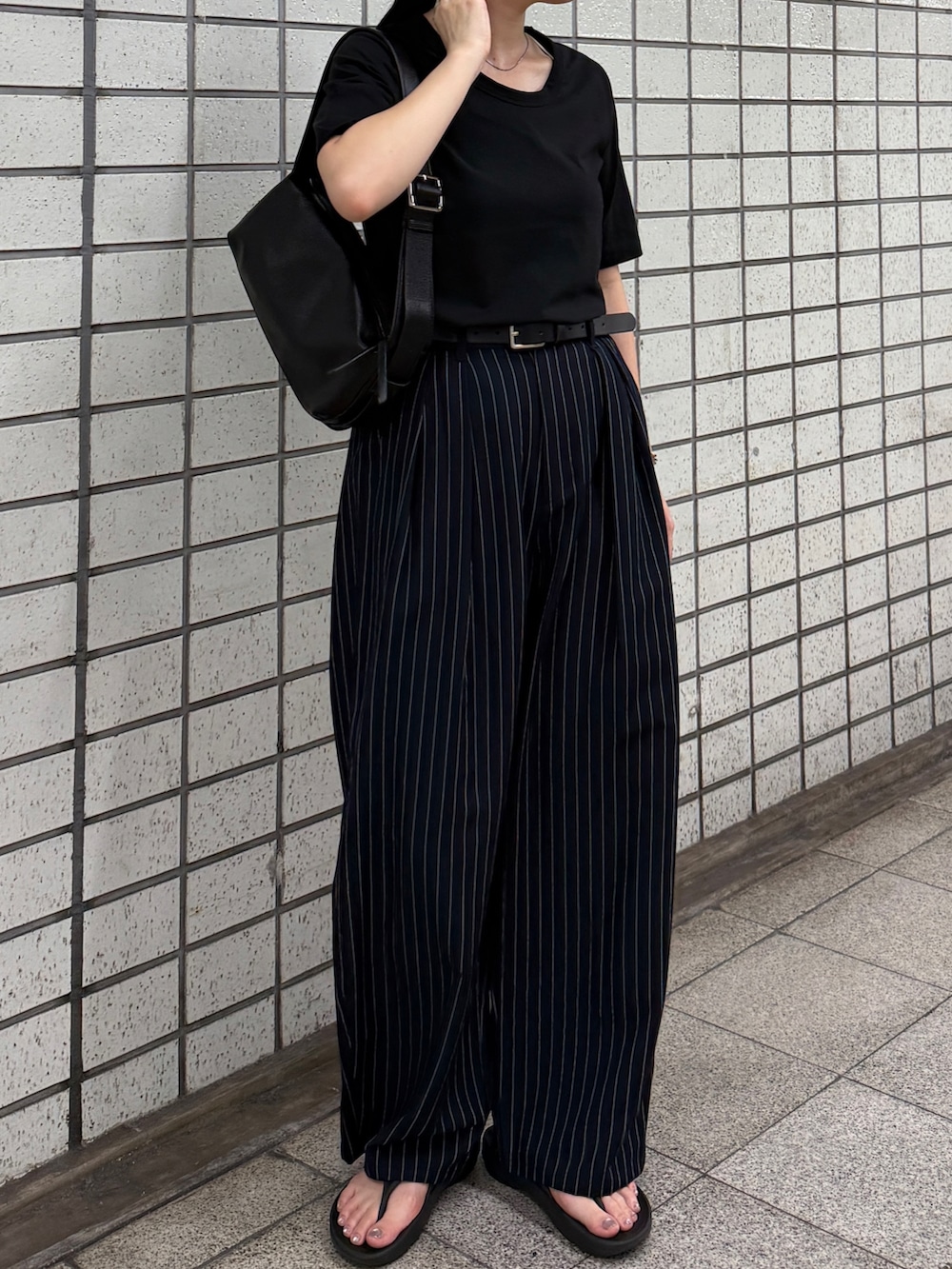 ブラック系のTシャツ/カットソー、ブルー系のその他パンツ、ブラック系のショルダーバッグを着用したレディースの秋コーディネートの3枚目の写真