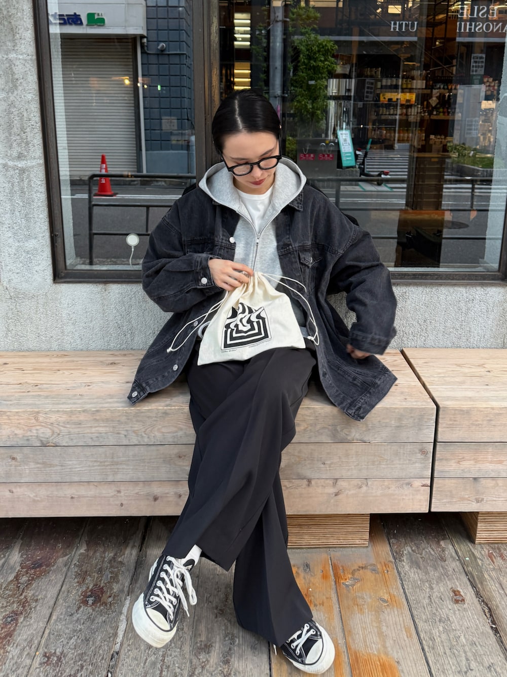 グレー系のパーカー、ホワイト系のTシャツ/カットソー、ブラック系のブルゾンを着用したレディースの秋コーディネートの3枚目の写真