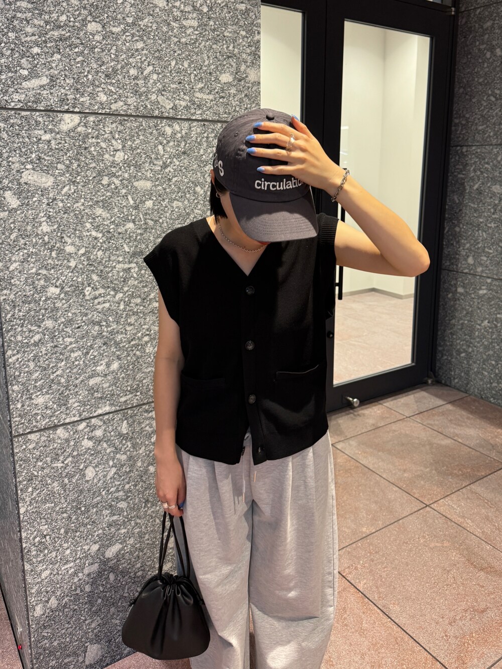 ブラック系のベスト、ブラック系のショルダーバッグを着用したレディースの秋コーディネートの2枚目の写真