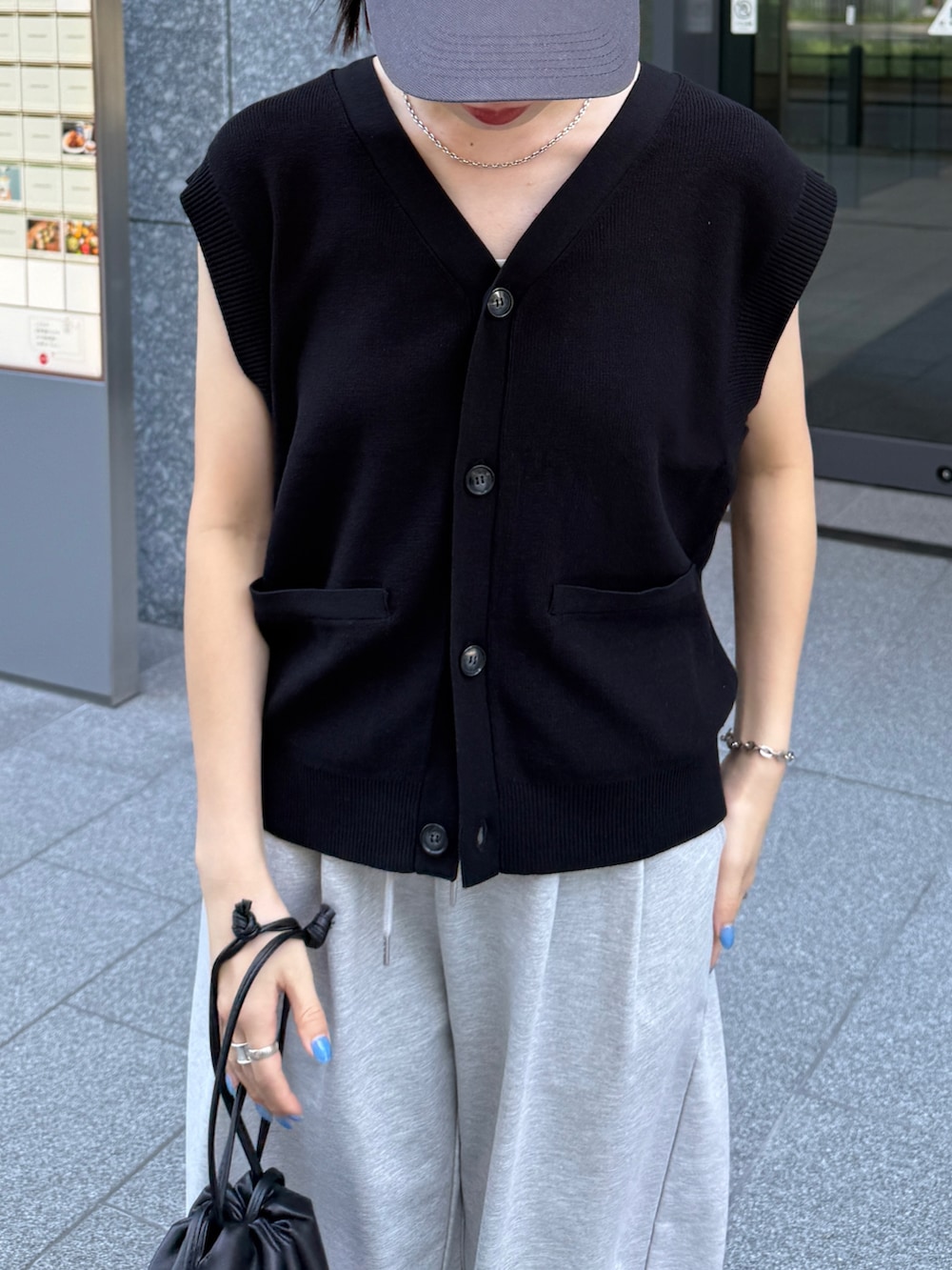 ブラック系のベスト、ブラック系のショルダーバッグを着用したレディースの秋コーディネートの4枚目の写真