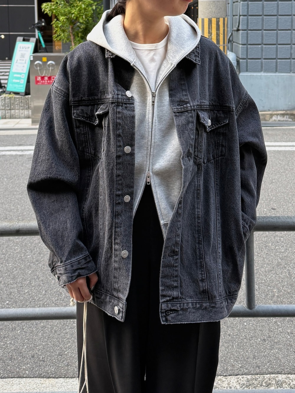 グレー系のパーカー、ホワイト系のTシャツ/カットソー、ブラック系のブルゾンを着用したレディースの秋コーディネートの4枚目の写真