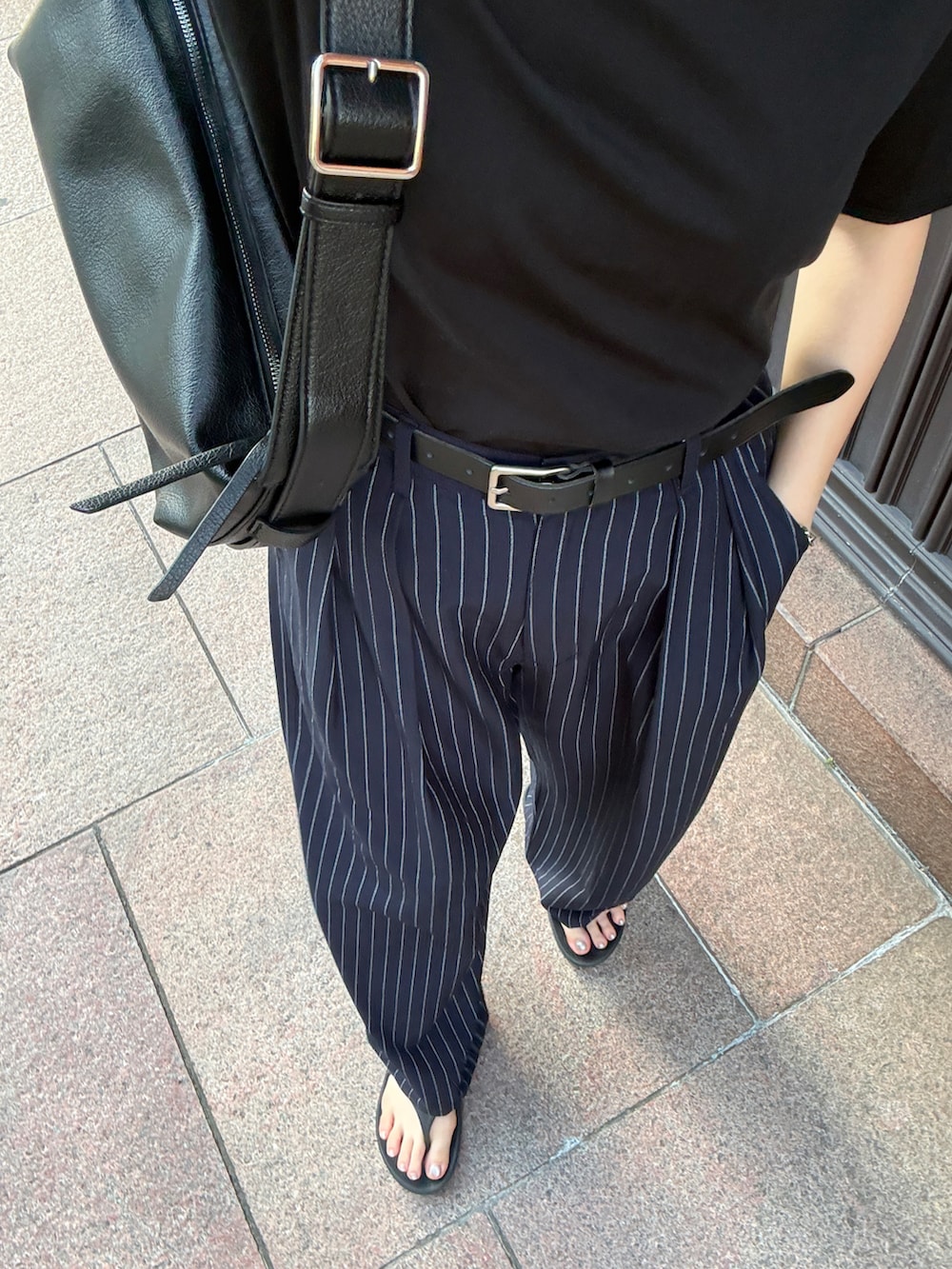 ブラック系のTシャツ/カットソー、ブルー系のその他パンツ、ブラック系のショルダーバッグを着用したレディースの秋コーディネートの2枚目の写真