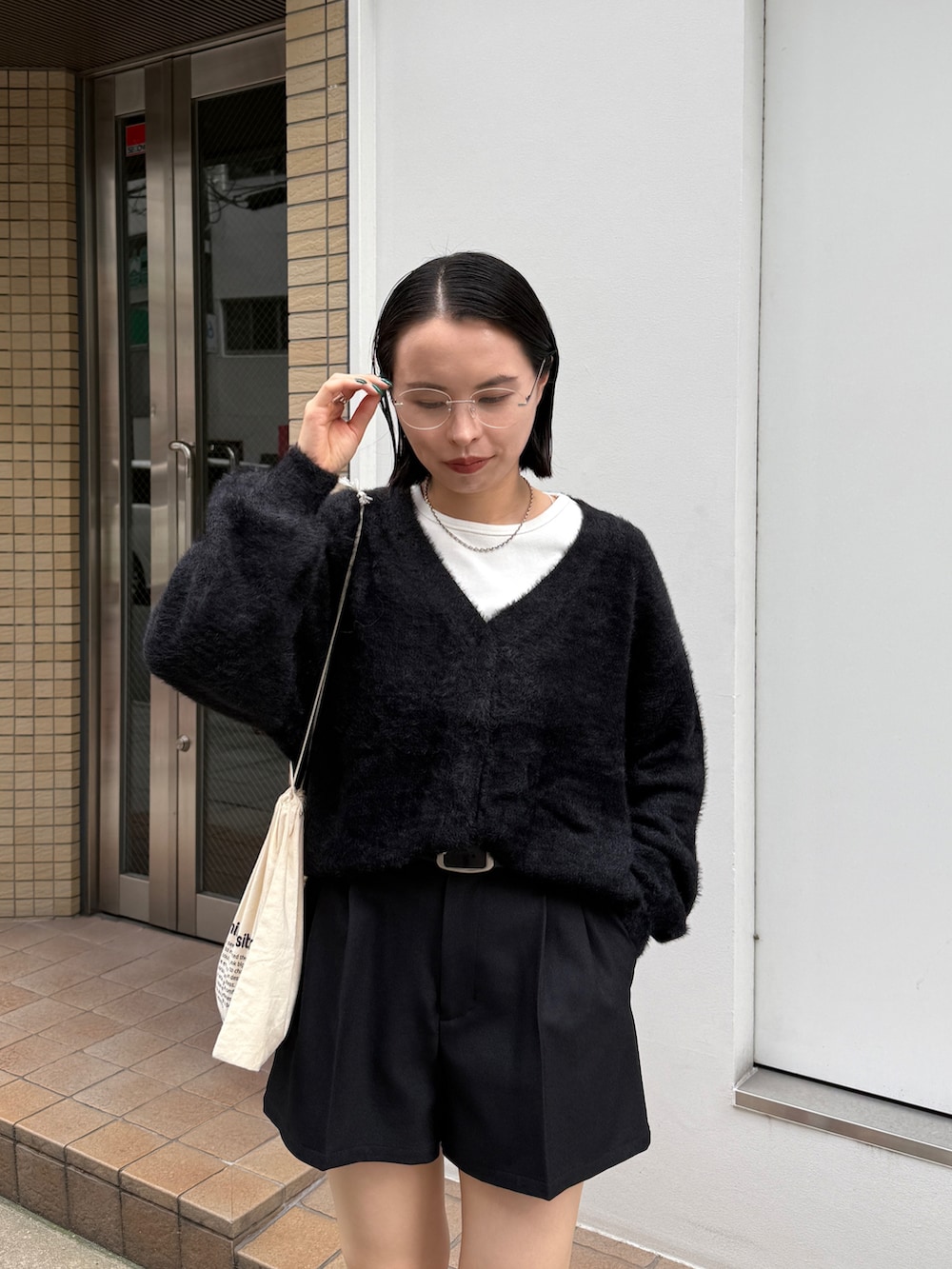 ブラック系のカーディガン/ボレロ、ホワイト系のTシャツ/カットソー、ブラック系のその他パンツを着用したレディースの秋コーディネートの2枚目の写真