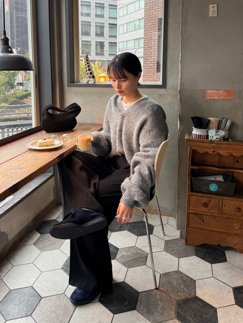 グレー系のニット/セーター、ホワイト系のTシャツ/カットソー、ブラック系のその他パンツを着用したレディースの秋コーディネートの2枚目の写真