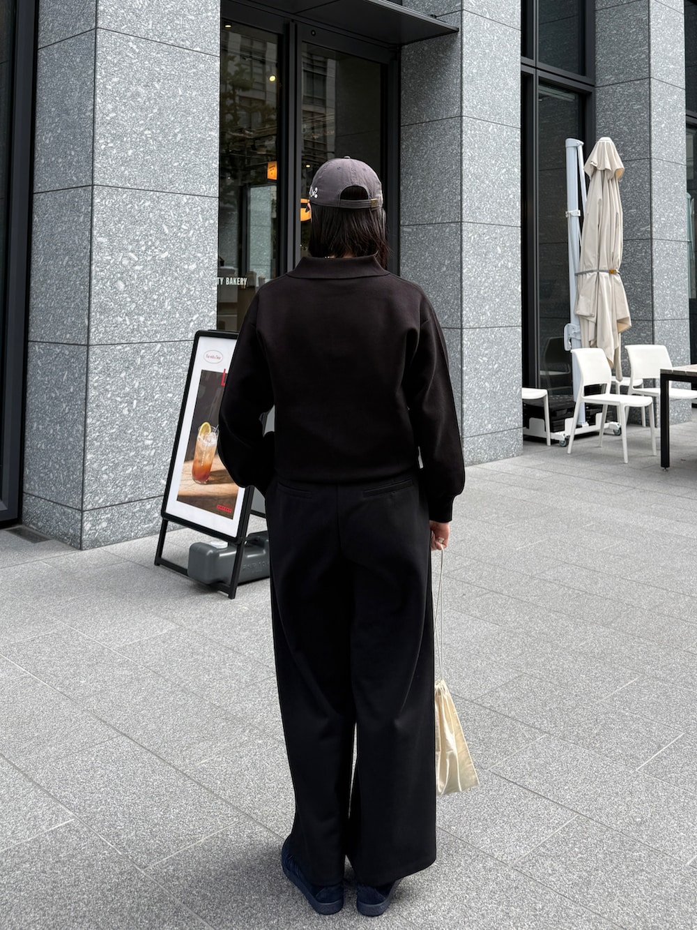 ブラック系のニット/セーター、ブラック系のその他パンツ、ホワイト系のTシャツ/カットソーを着用したレディースの秋コーディネートの3枚目の写真