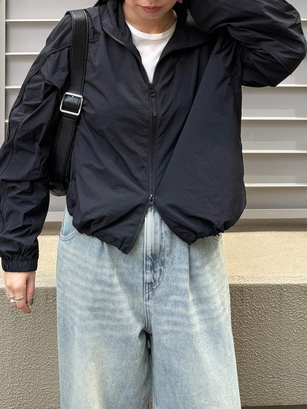 グレー系のTシャツ/カットソー、ブラック系のブルゾン、ブラック系のショルダーバッグを着用したレディースの秋コーディネートの2枚目の写真